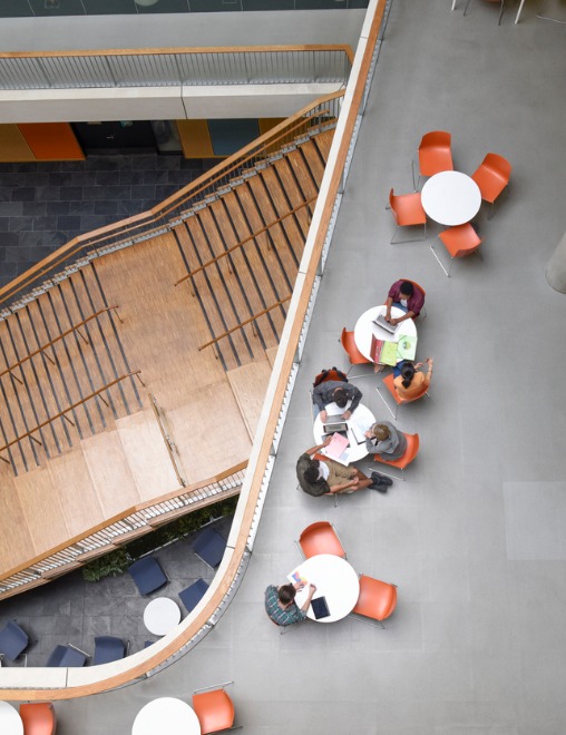 Employees sitting at tables overlooking staircase