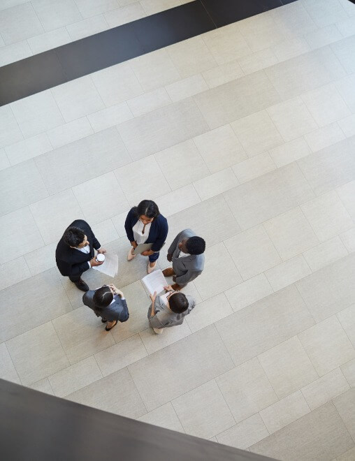 five executives standing around talking