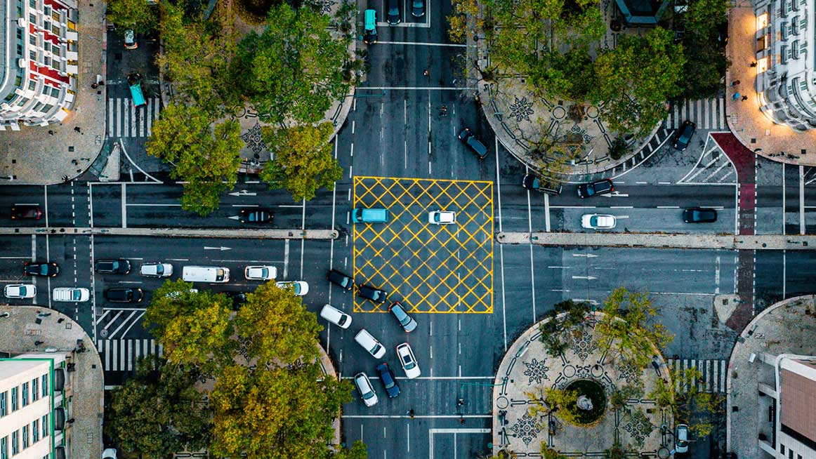 Top down aerial view of cars driving through intersection